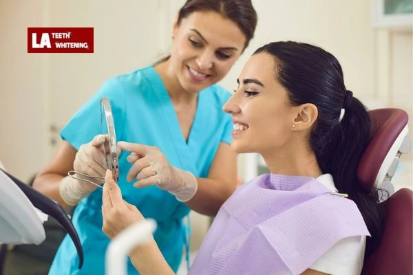 A person looking in the mirror with a happy expression after completing a successful whitening session Oxfordshire